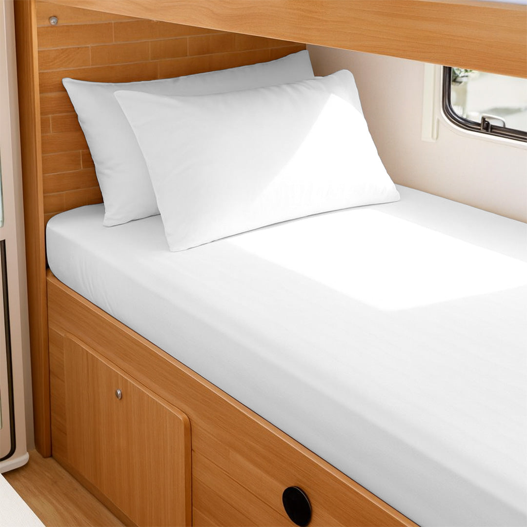 RV King fitted sheet set with pillowcases for a camper bed against a wall